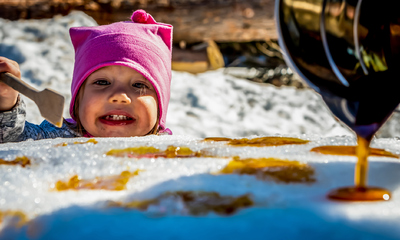 Little girl holding a spatula at a sugar shack