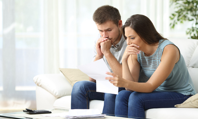 Concerned couple reading a mortgage lender