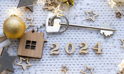 House key with keychain cottage on festive knitted background